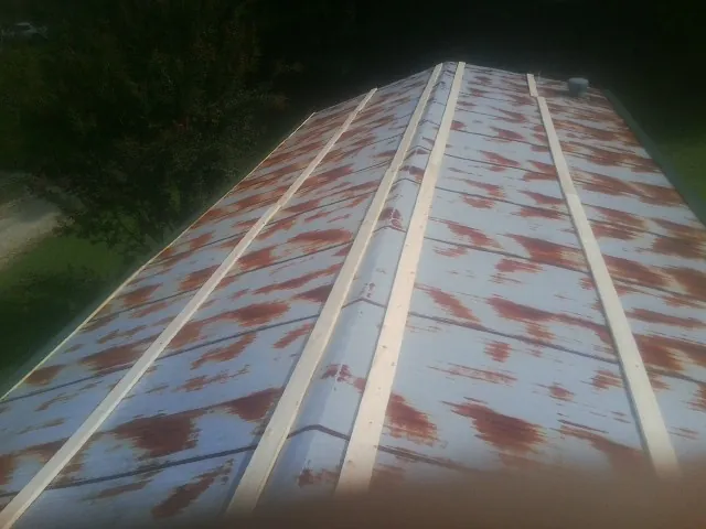 Rusted metal roof panels with new wood purlins before replacement — Storm Damage Roof Repair in Loveville by Roofing Brothers