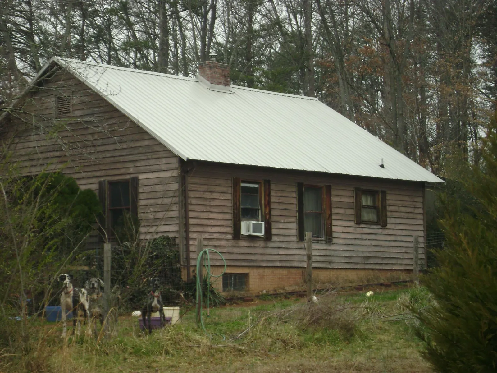 White metal roof on an old wood sided farmhouse, from a Metal Roof Installation job in Loveville